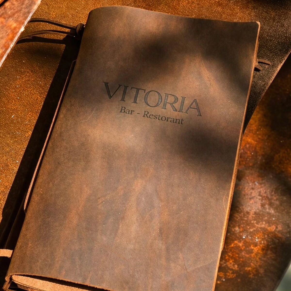 Warm distressed brown menu cover with dark engraved branding