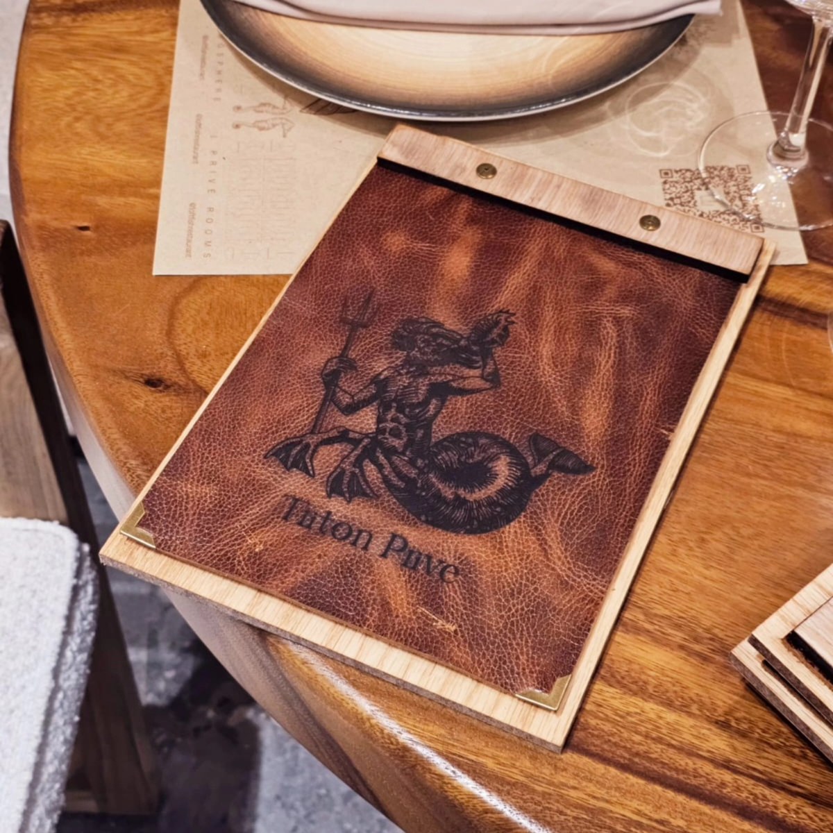Triton menu with a wood backing, brown leather panel and metal corner details