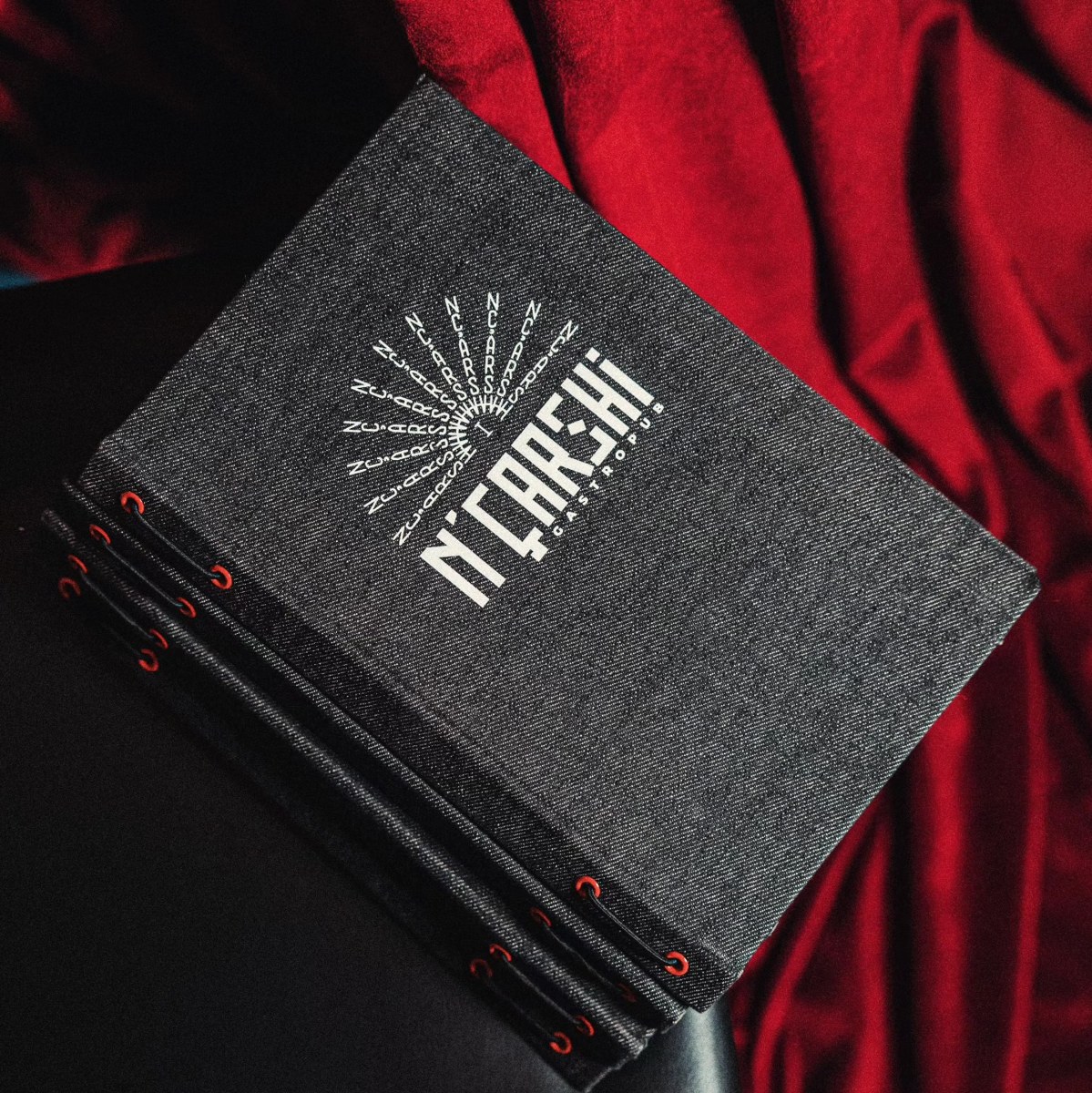 Charcoal woven texture menu covers with red eyelets and cord binding